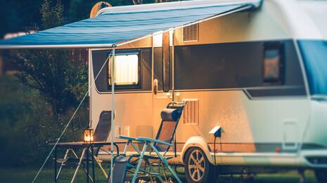 Campingvogn med markise og utemøbler en sommerkveld.