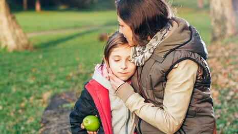 Mor trøster barn ute i park