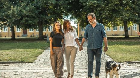 Familie går på tur med hunden