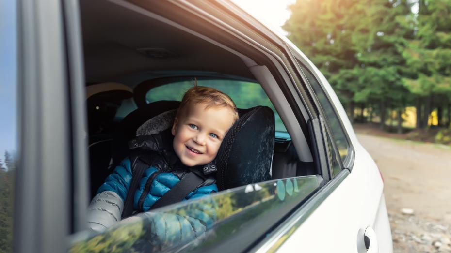 Baby som sitter i baksetet og smiler til kamera