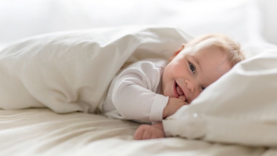 Baby som smiler til kamera 