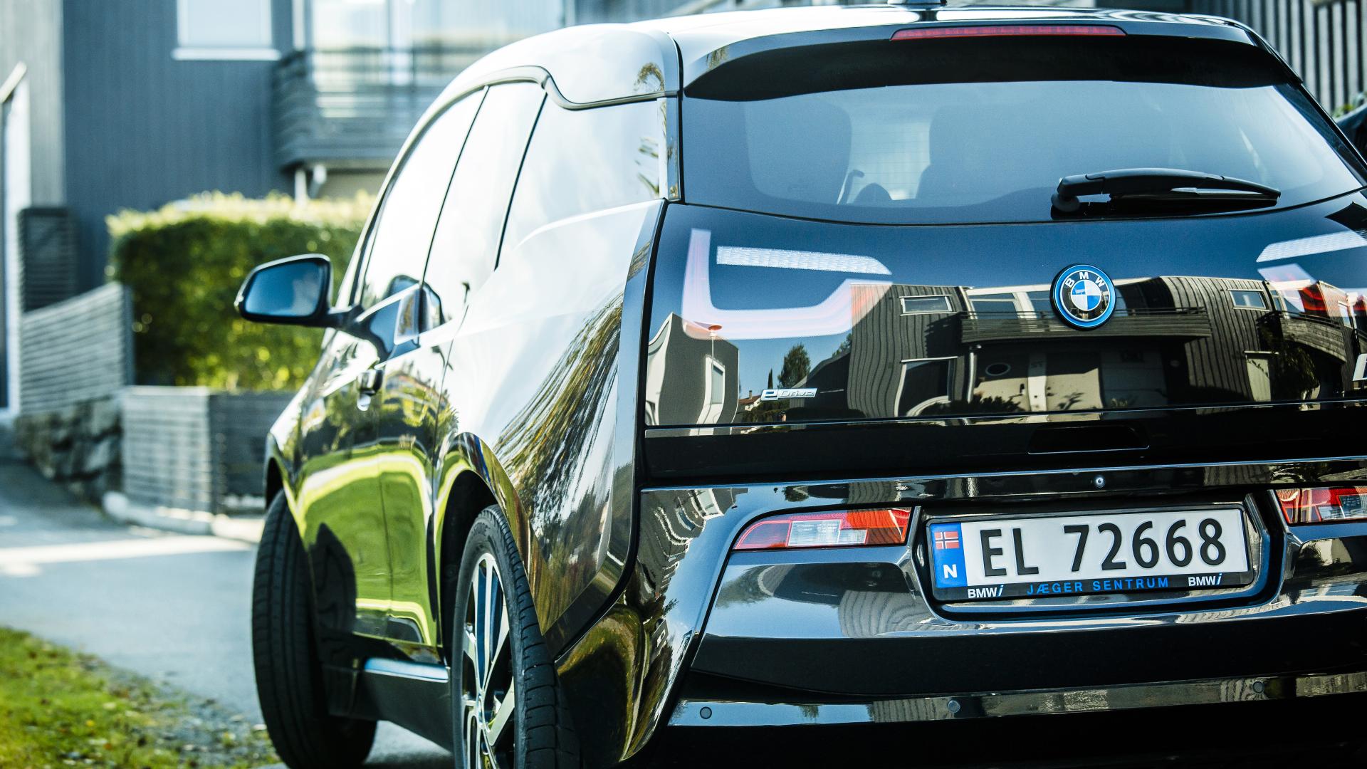Elbil som står parkert utenfor hus