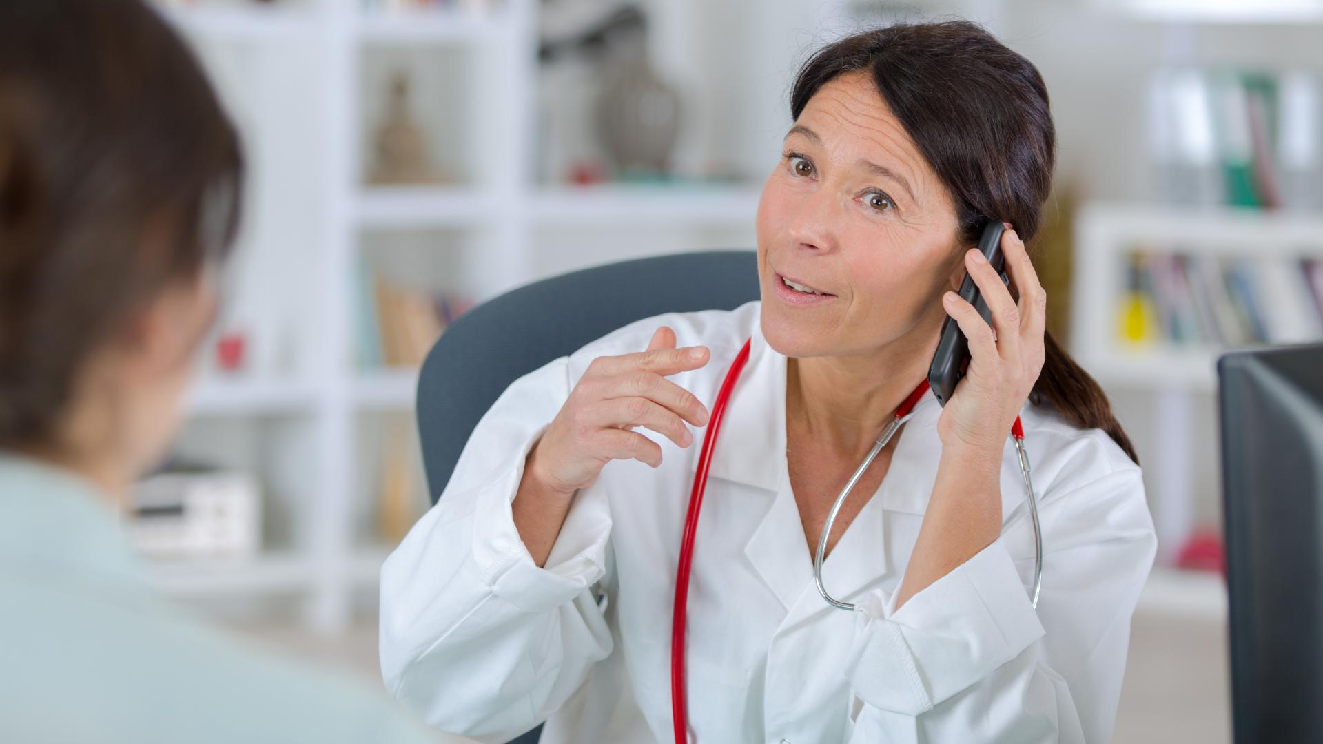 Lege snakker i telefon med pasient