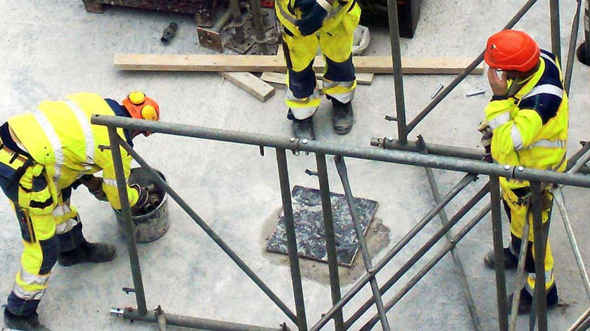 Tre anleggsarbeidere på jobb. Foto.