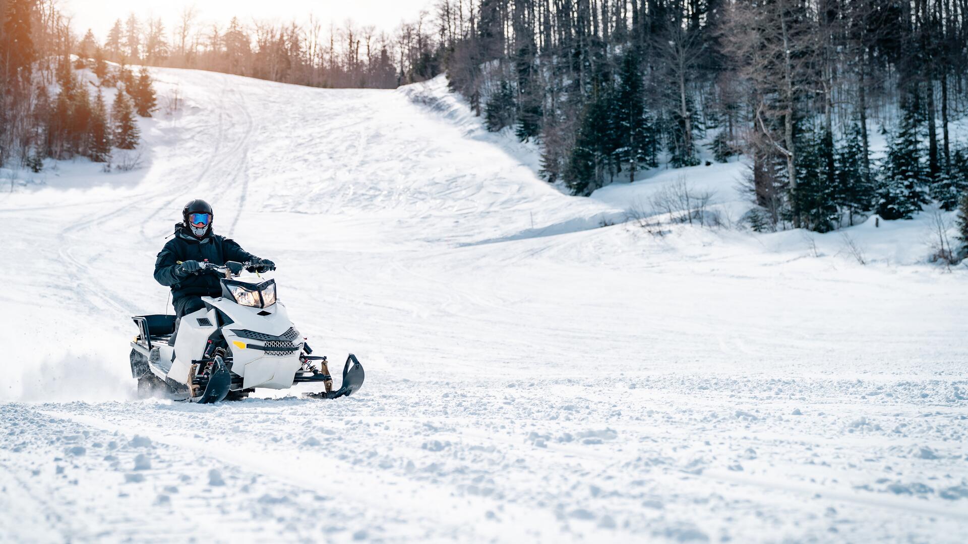 Snøscooter kjører på snø