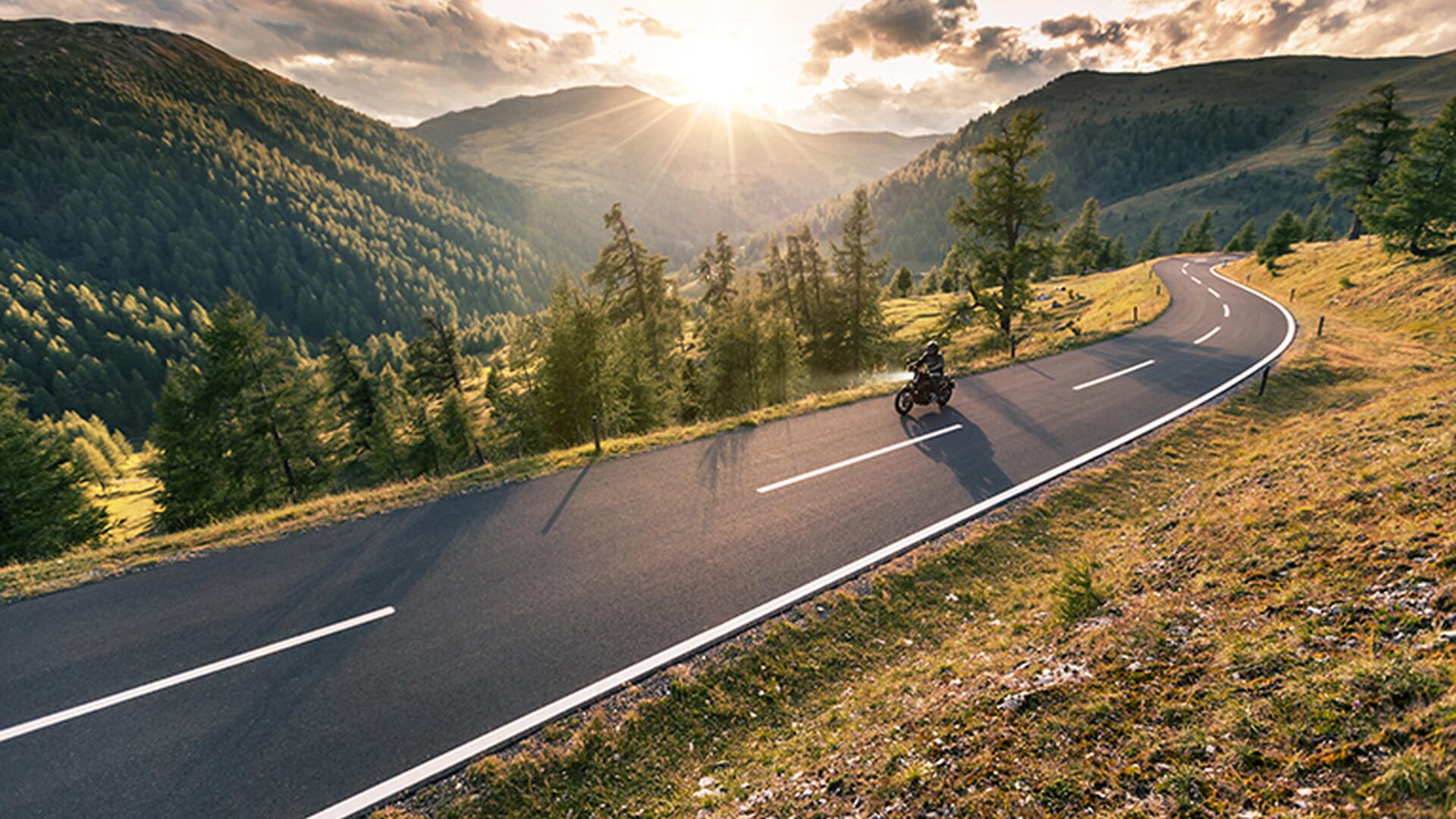 Motorsyklist som kjører i et fjellandskap