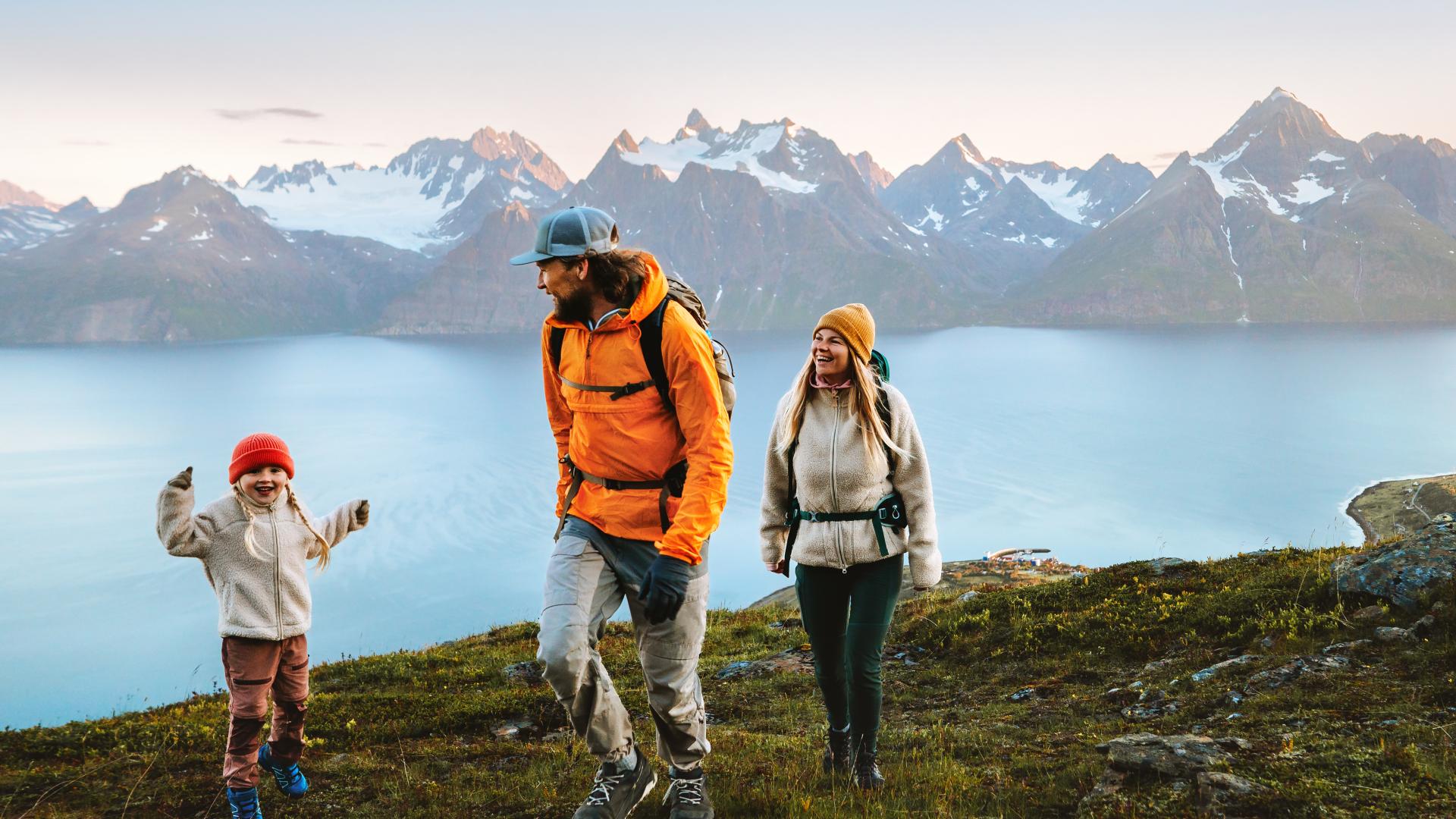 Barn poserer foran naturlandskap. Familie på tur med Reise ekstra forsikring.