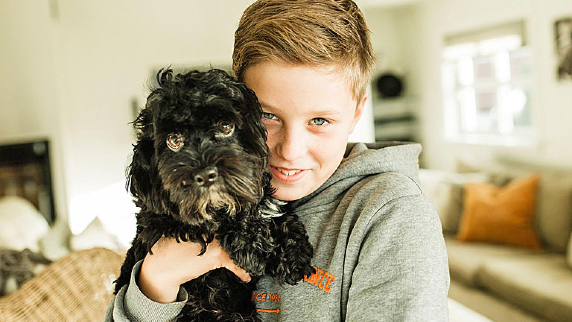 Gutt som koser med sin hund