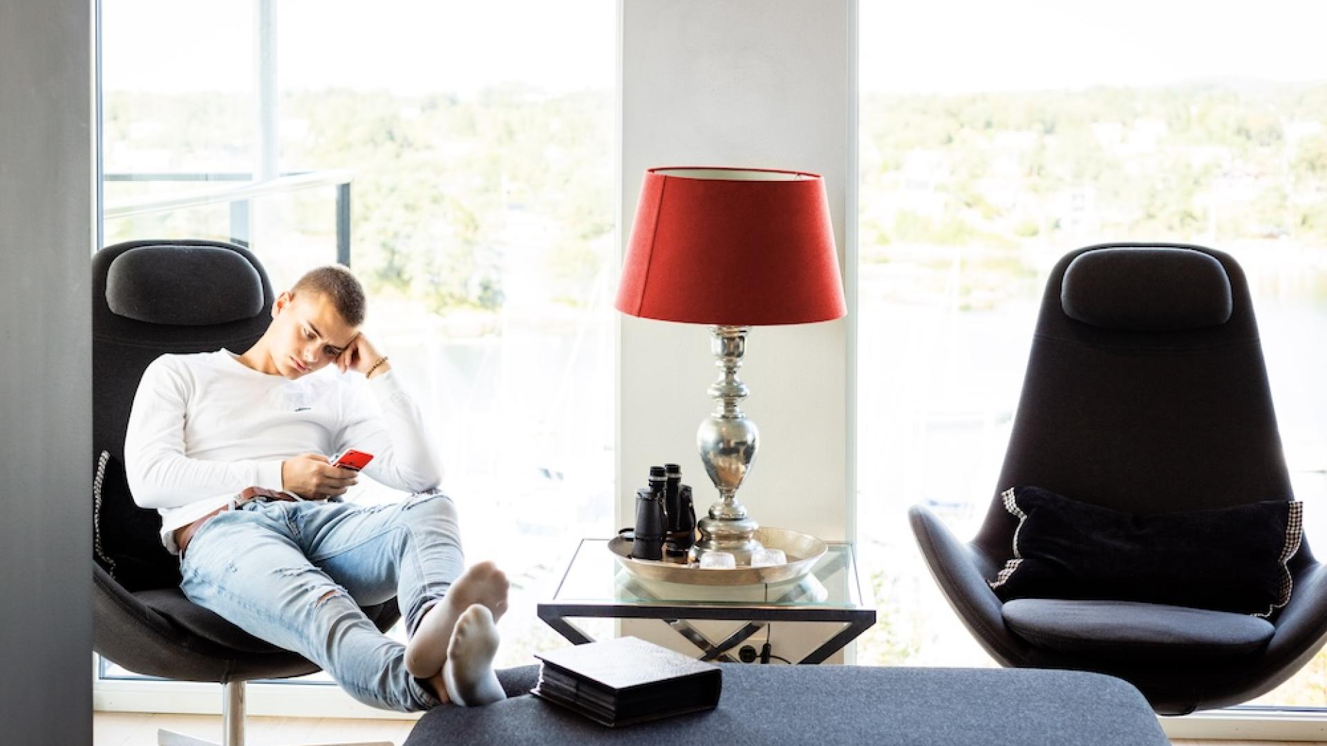 Gutt som sitter på telefonen 