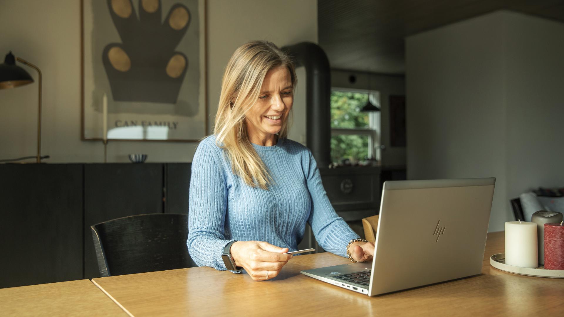 En dame sitter og ser på en laptop