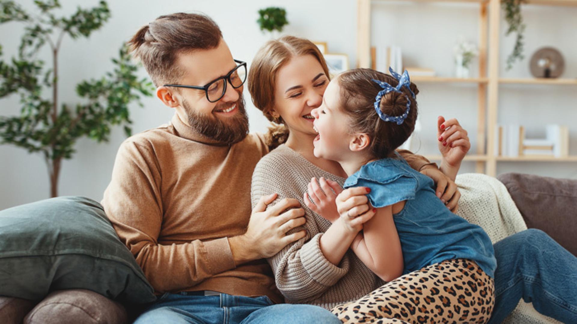Lykkelig familie som sitter i en sofa sammen