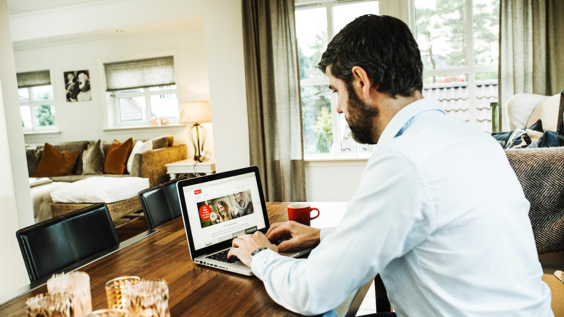 En dame sitter og ser på en laptop