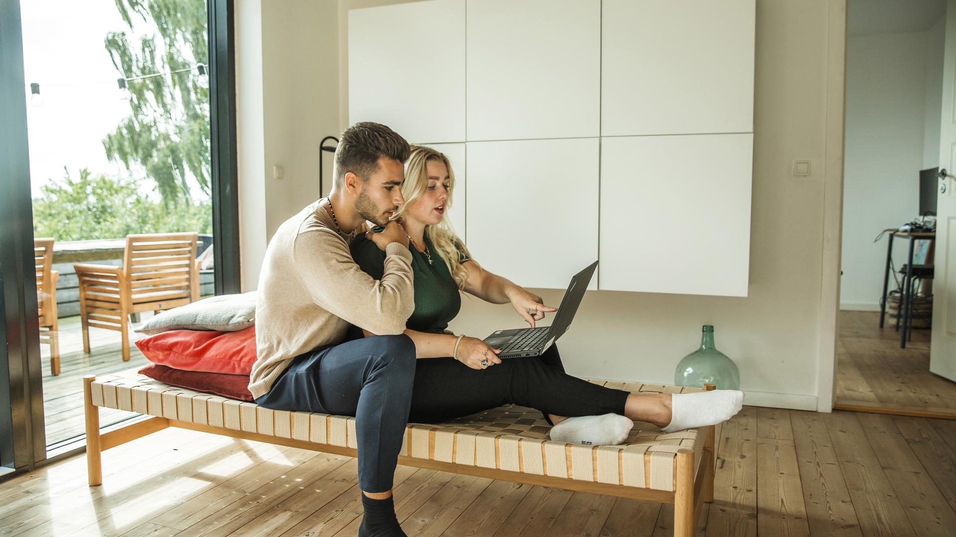 Ungt par ser på laptop sammen