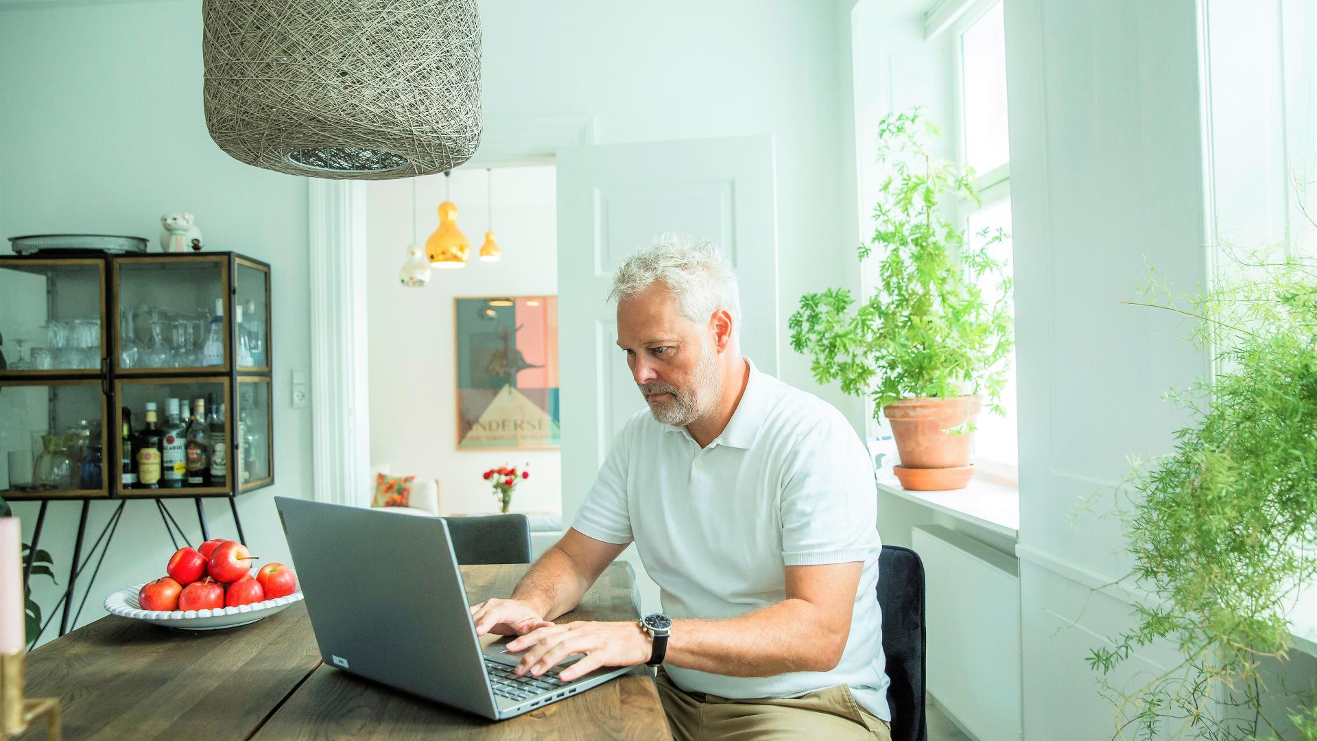 Mann som sitter hjemme og jobber fra pc-en 