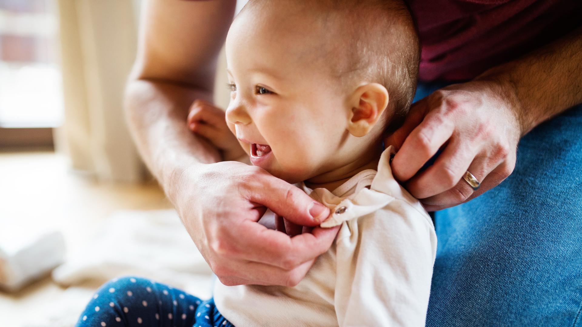 baby som blir påkledd 