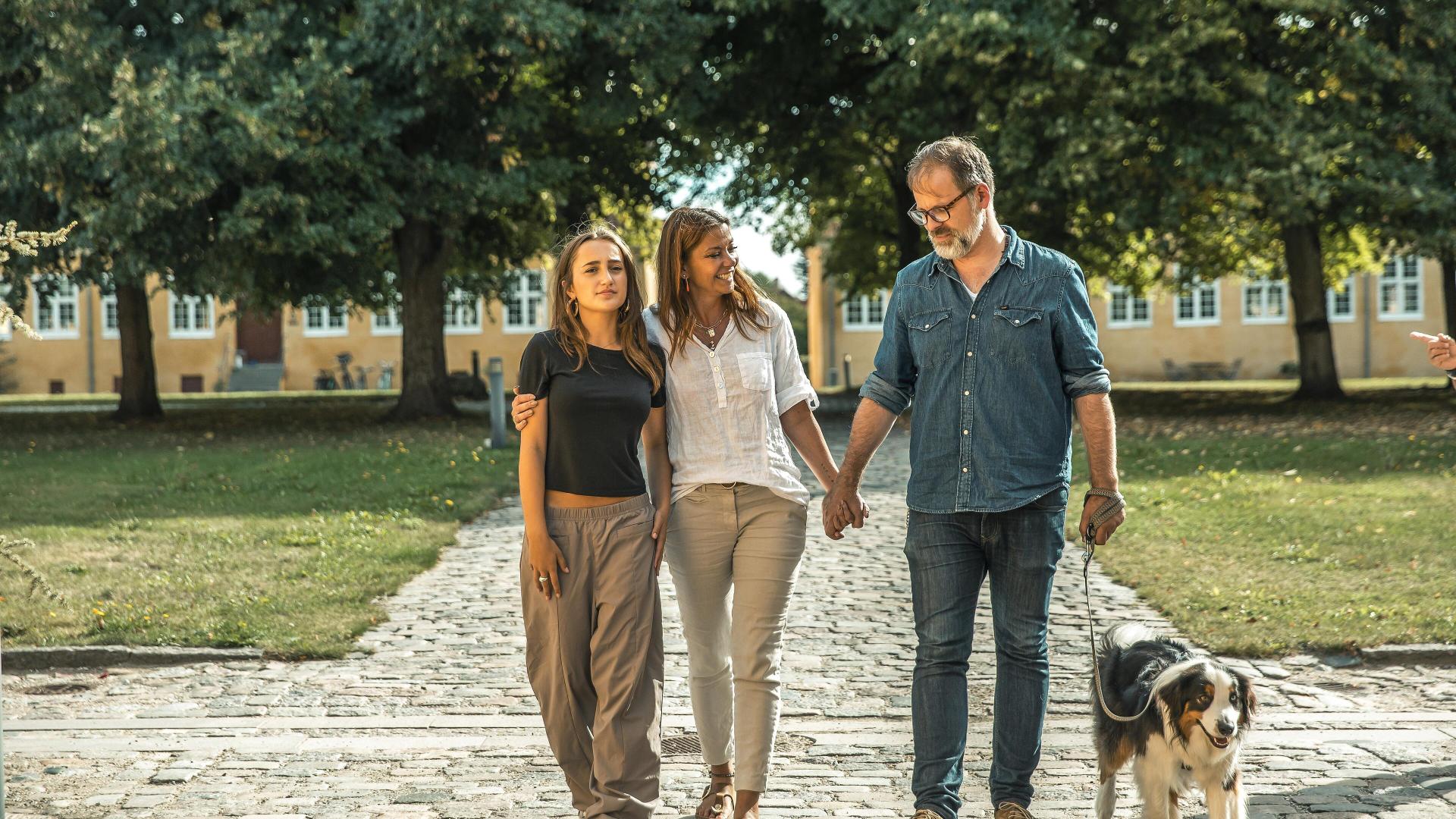 Familie går på tur med hunden