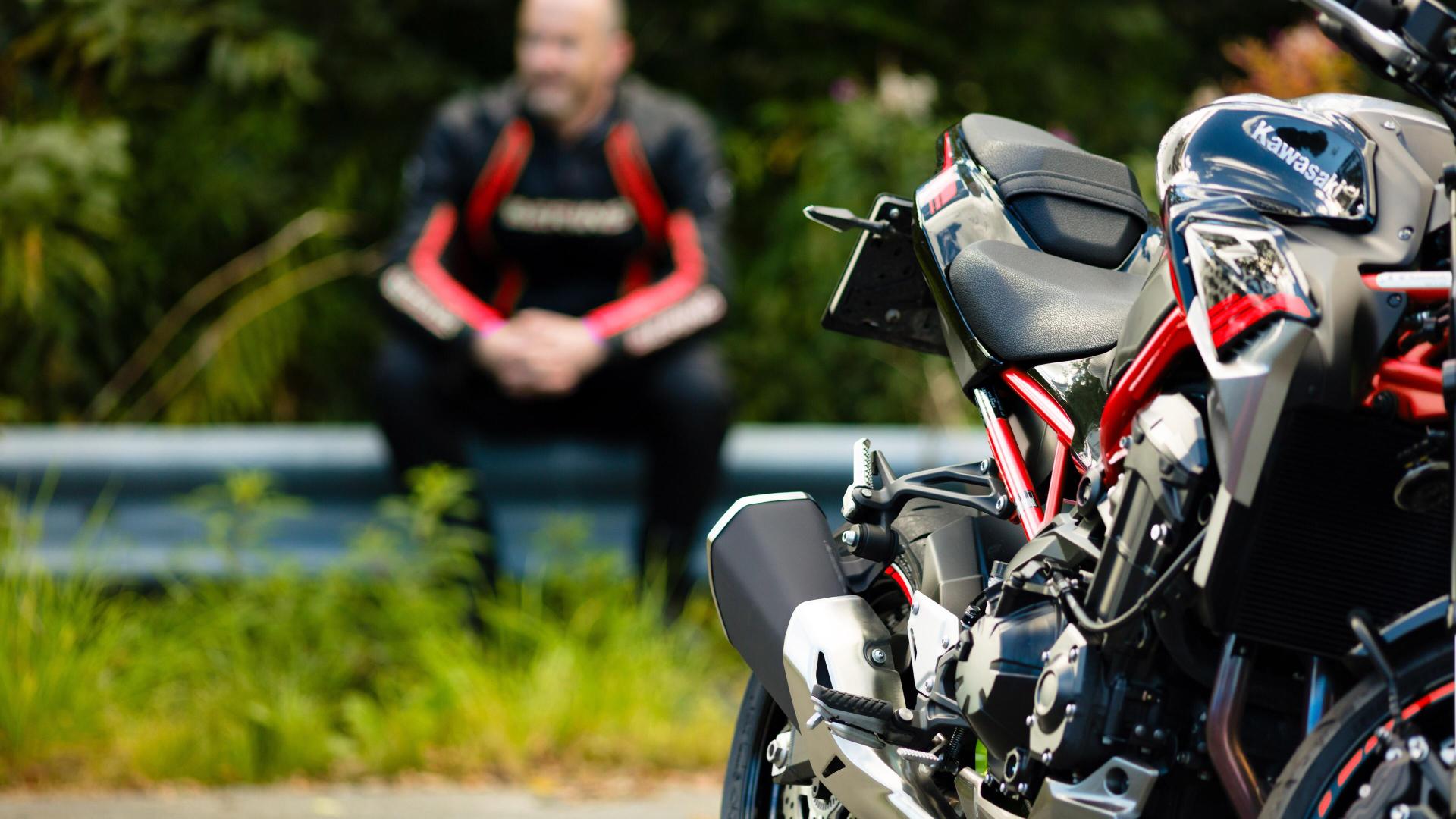 Mann sitter med motorsykkel