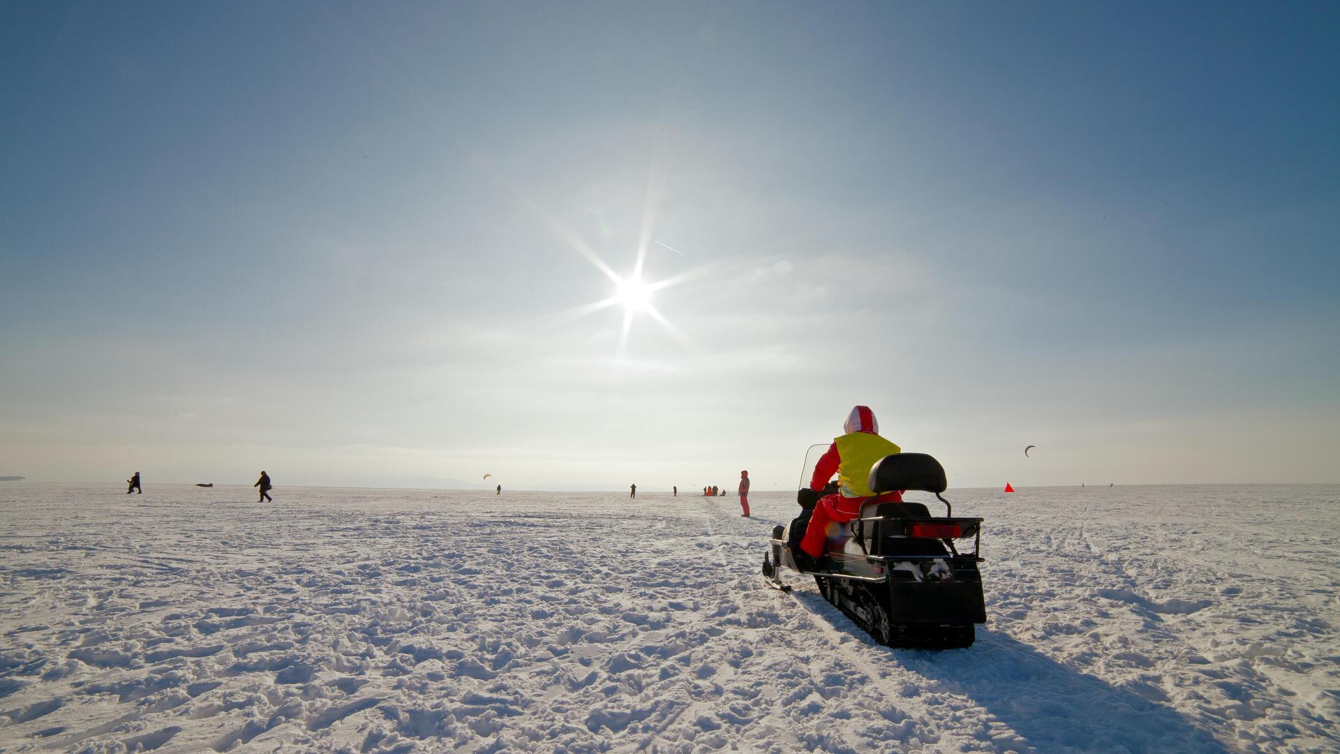Mann ute å kjører snøscooter.jpg