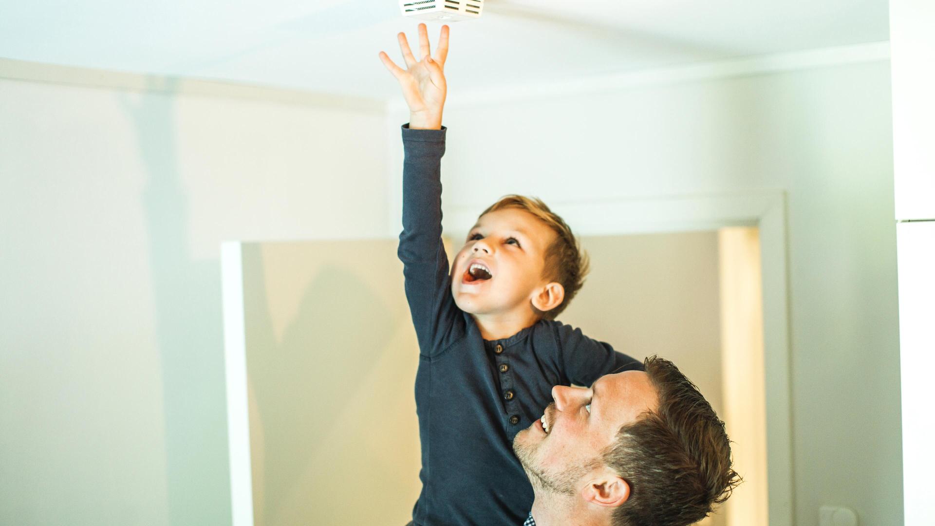 Far og sønn sjekker røykvarsler