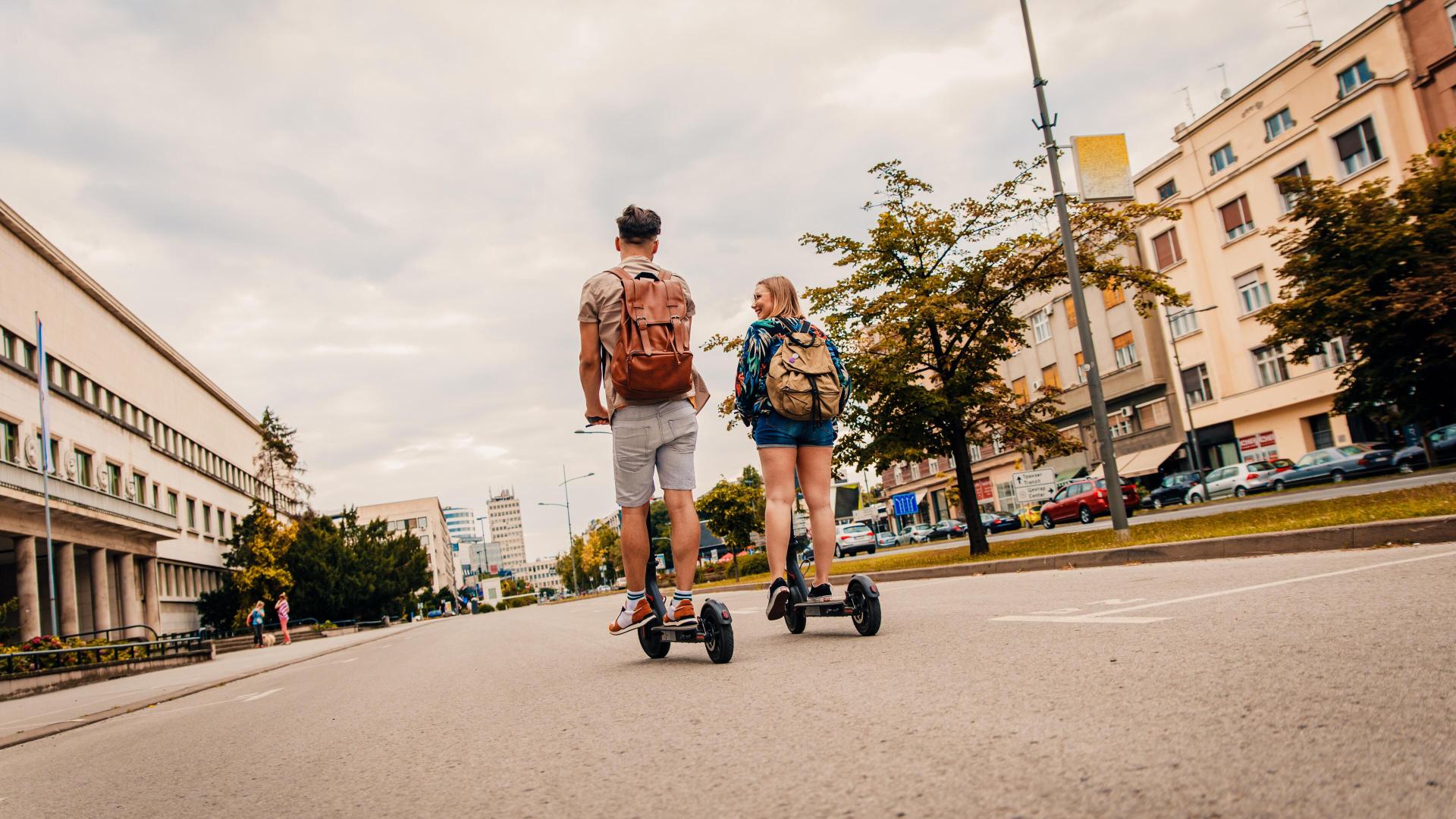 Mann og kvinne kjører elsparkesykkel med elsparkesykkelforsikring