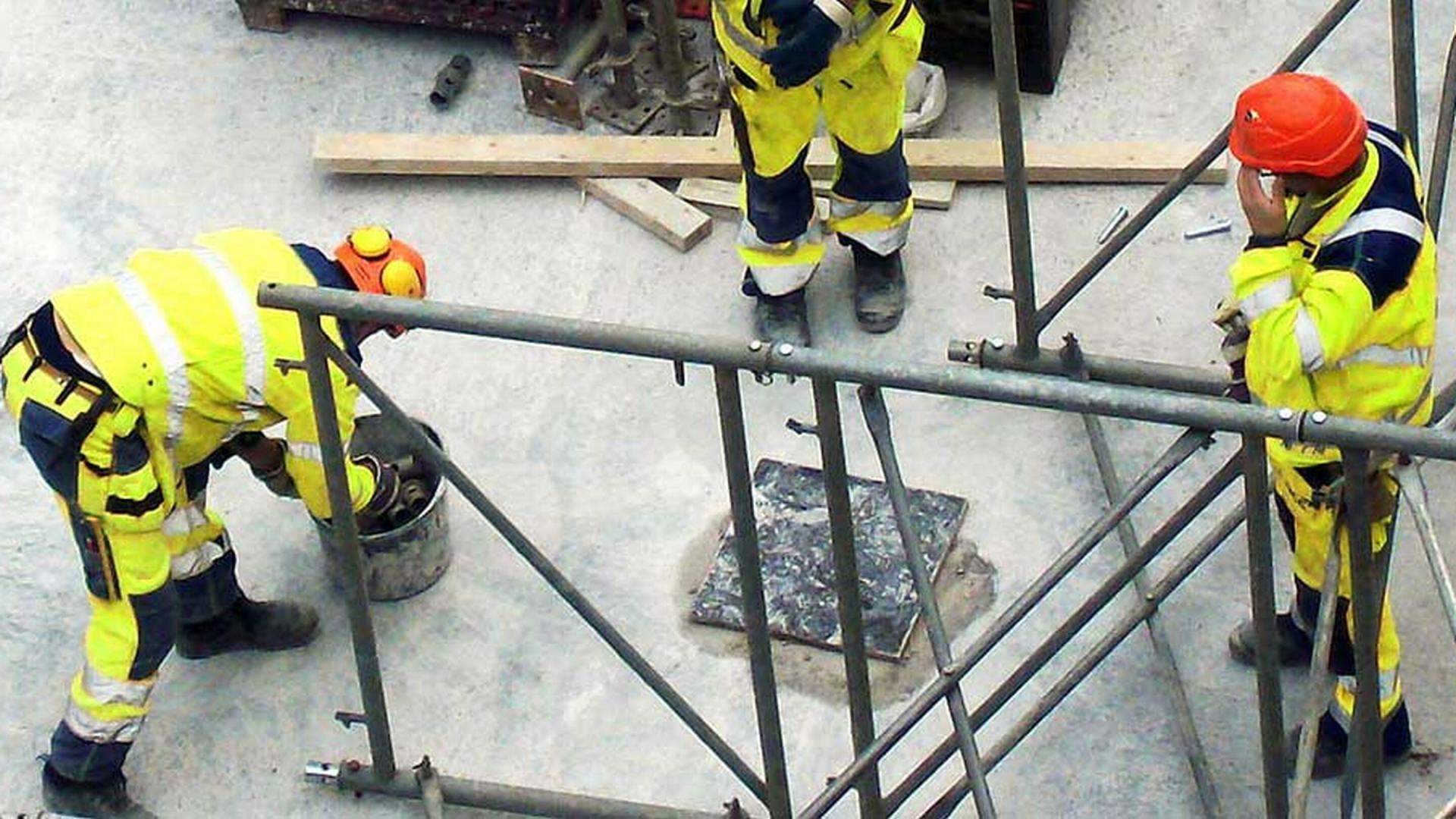 Tre anleggsarbeidere på jobb. Foto.