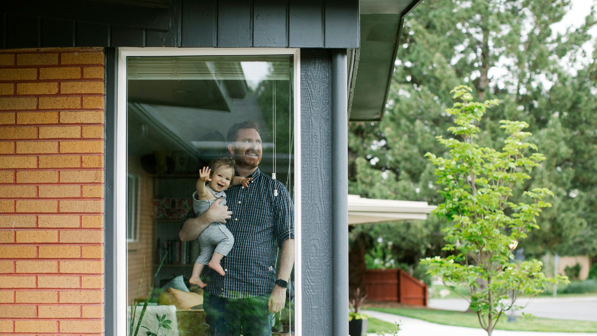 Far og barn ser ut vinduet