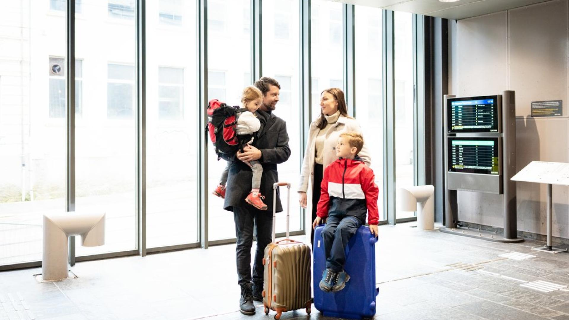 Gutt på flyplassen som venter på bagasje. Er dekket gjennom reiseforsikringen til familien