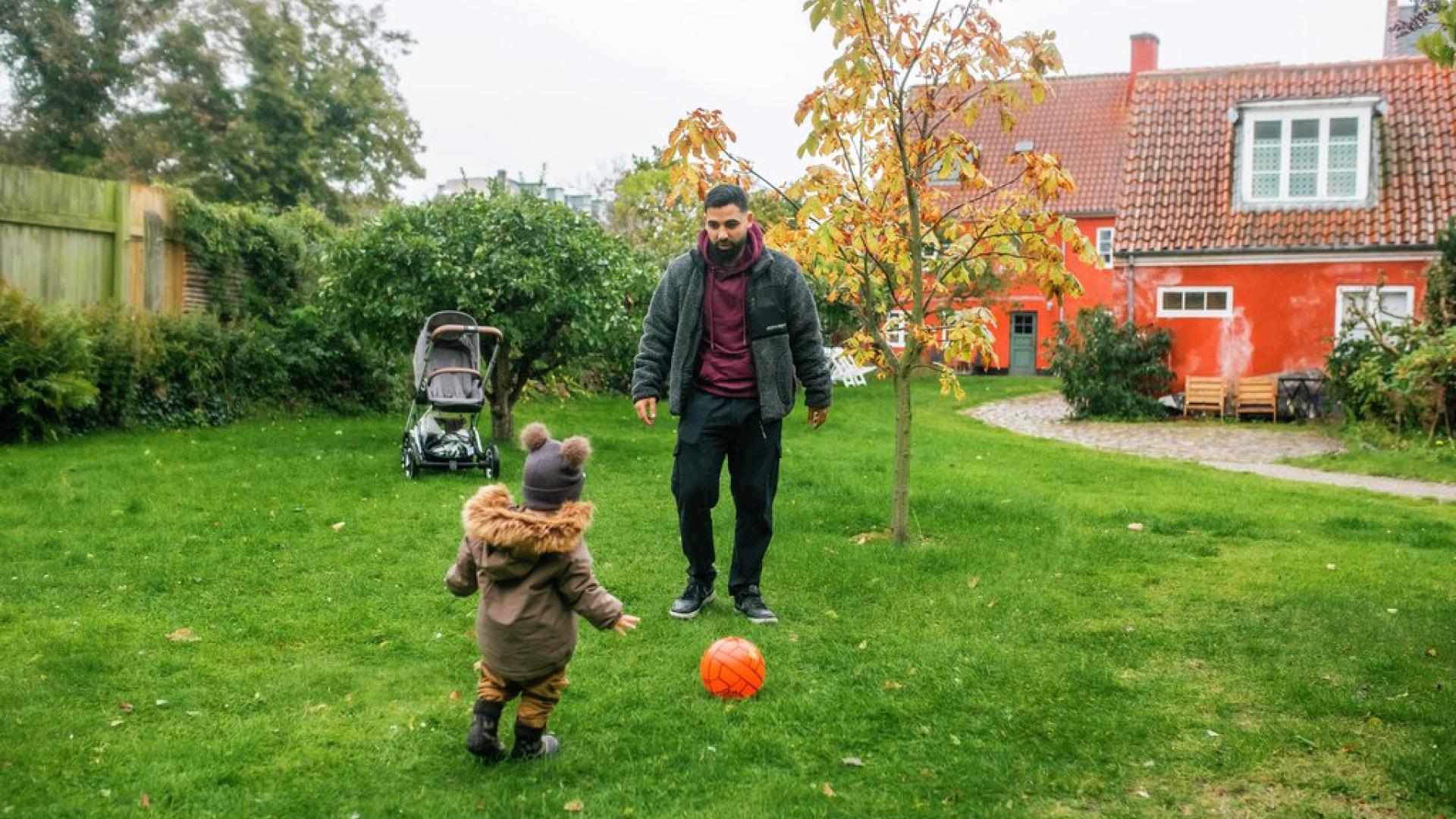 Far og sønn spiller fotball i hagen
