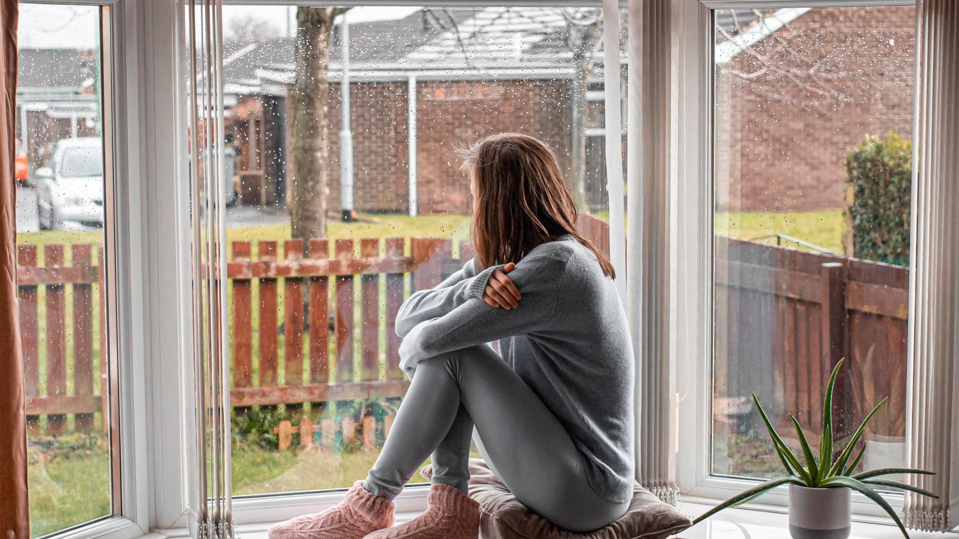 kvinne sitter i vinduskarm.jpg