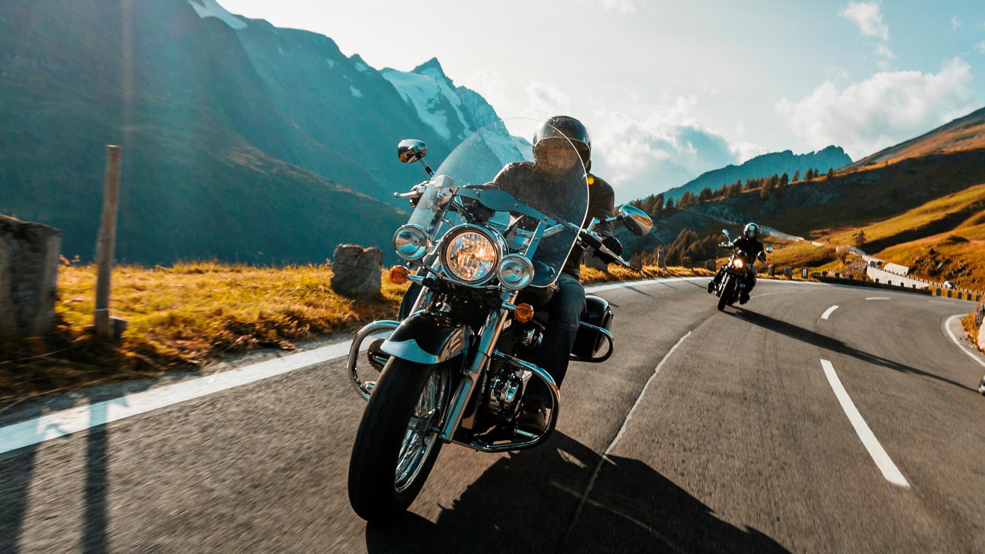 To mennesker som kjører motorsykkel på veien