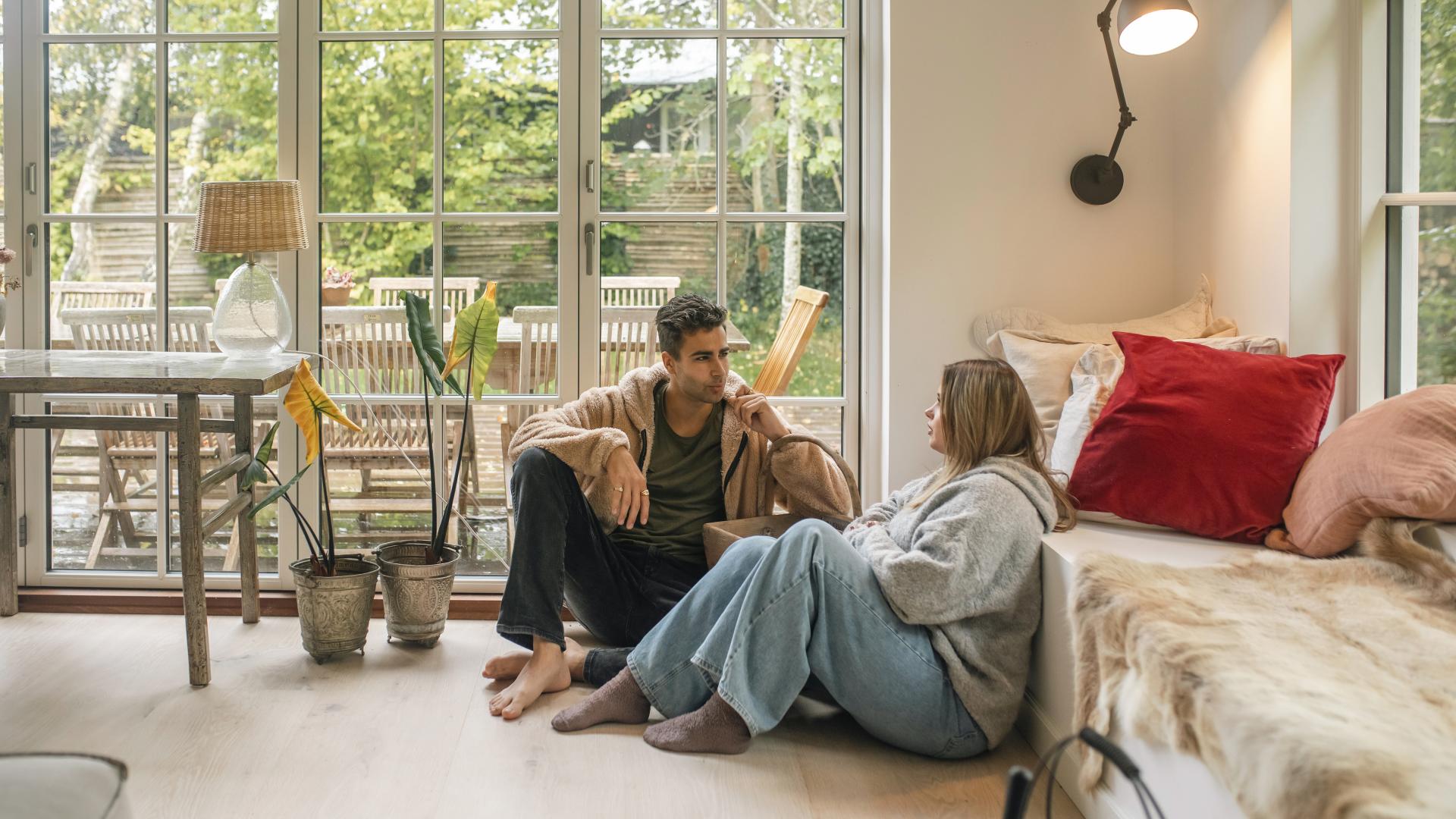 Ungt par som sitter sammen på gulvet Young living 