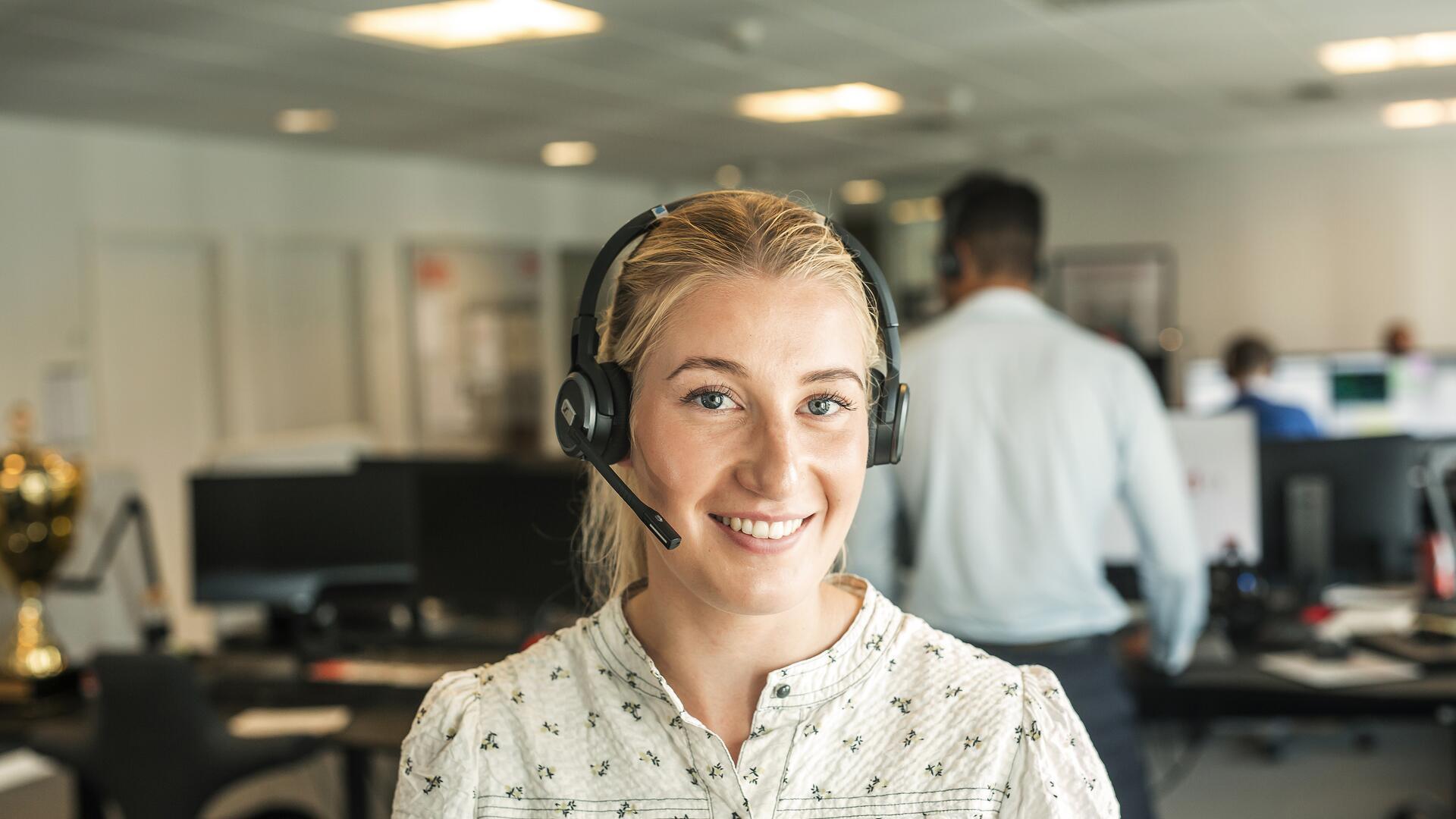 Smilende kvinne som svare på telefon
